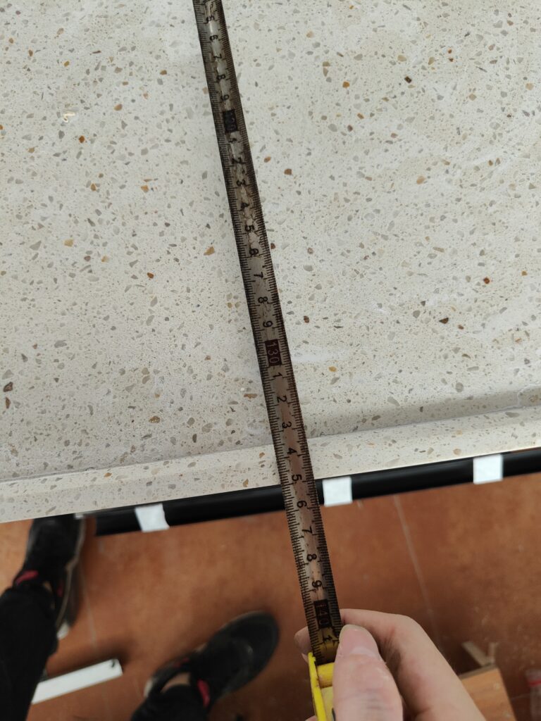 Tape measuring overall length and width of quartz countertop for EU kitchen order 